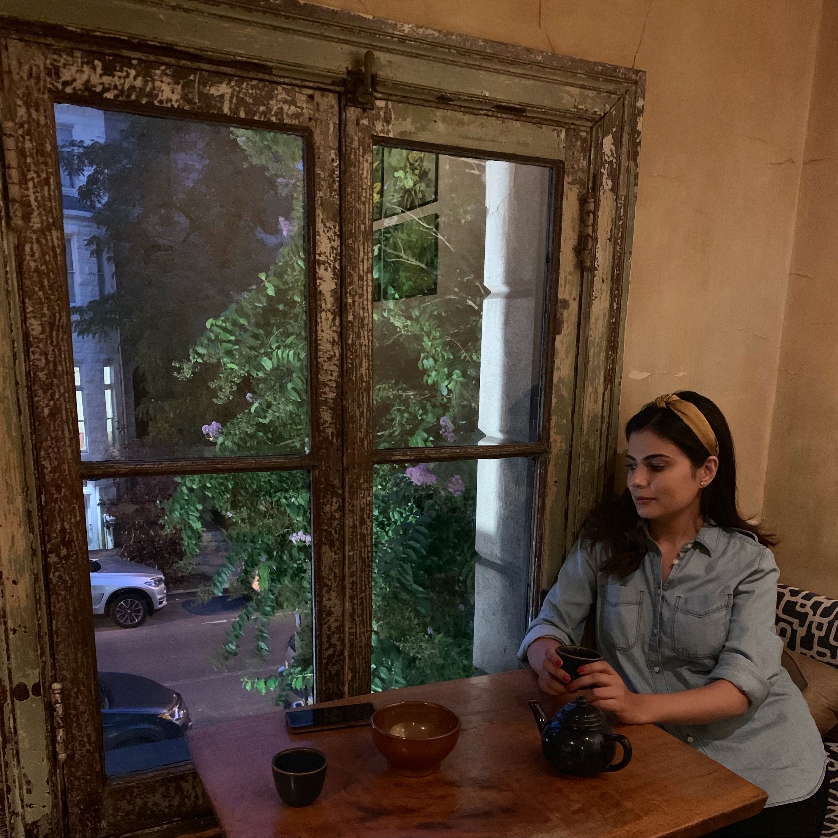 Woman holding a cup of tea, sitting in quiet reflection, enjoying the simple moments of life.